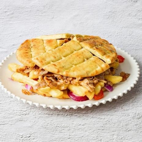 Mr Gyros skepasti gyro pita sandwich stuffed with meat, onions, and french fries.